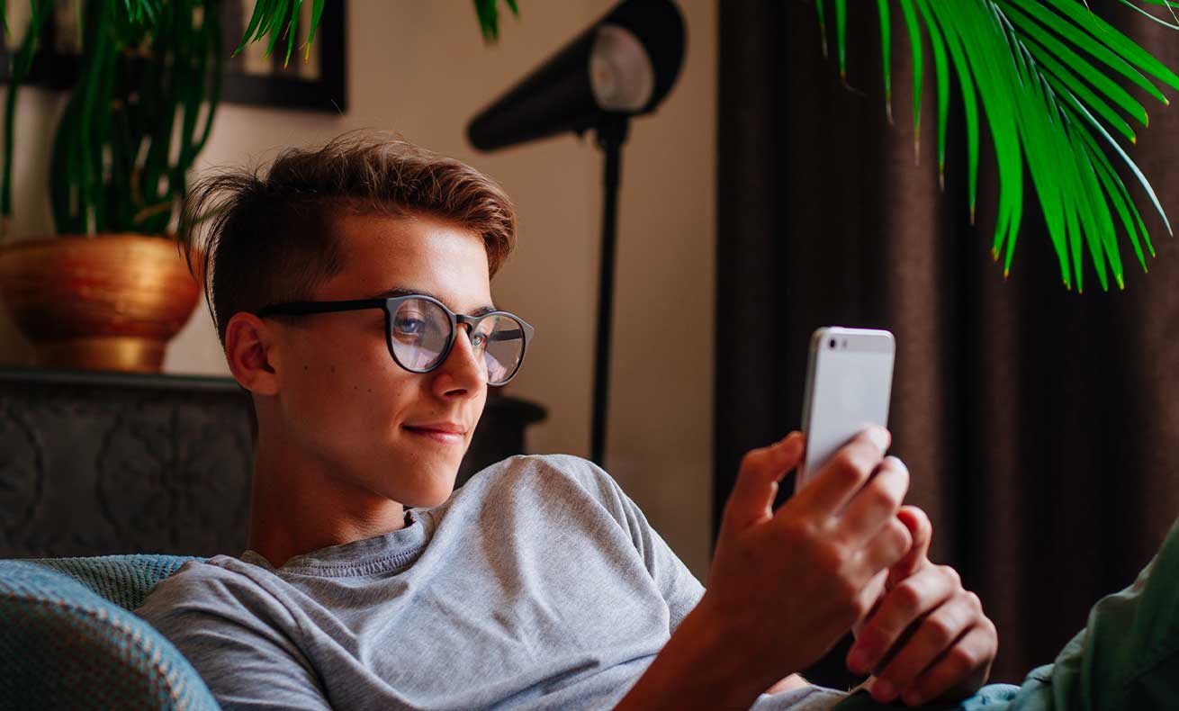A young man engrossed in his phone.