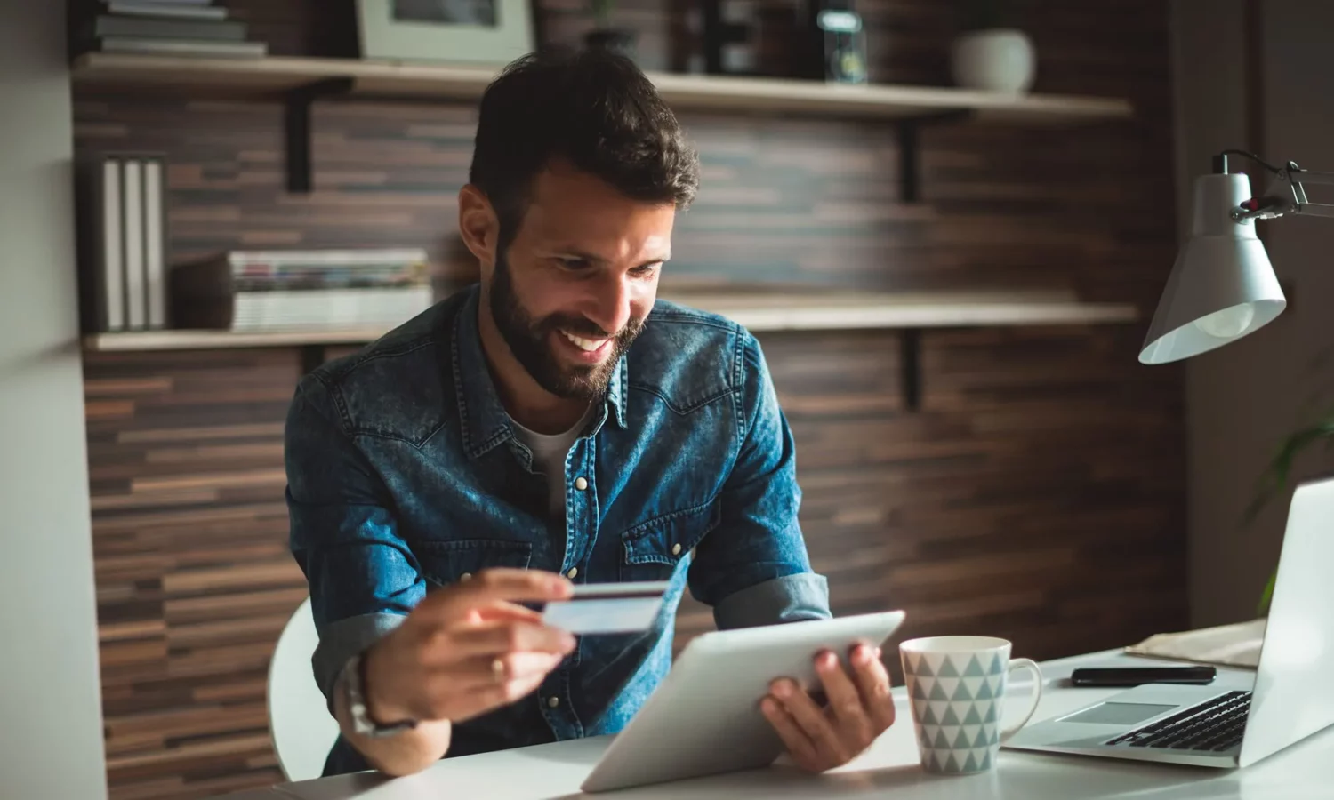 Man sitting at desk holding tablet
