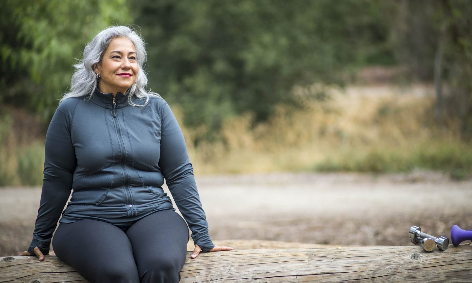 Woman sitting on a bench, smiling.