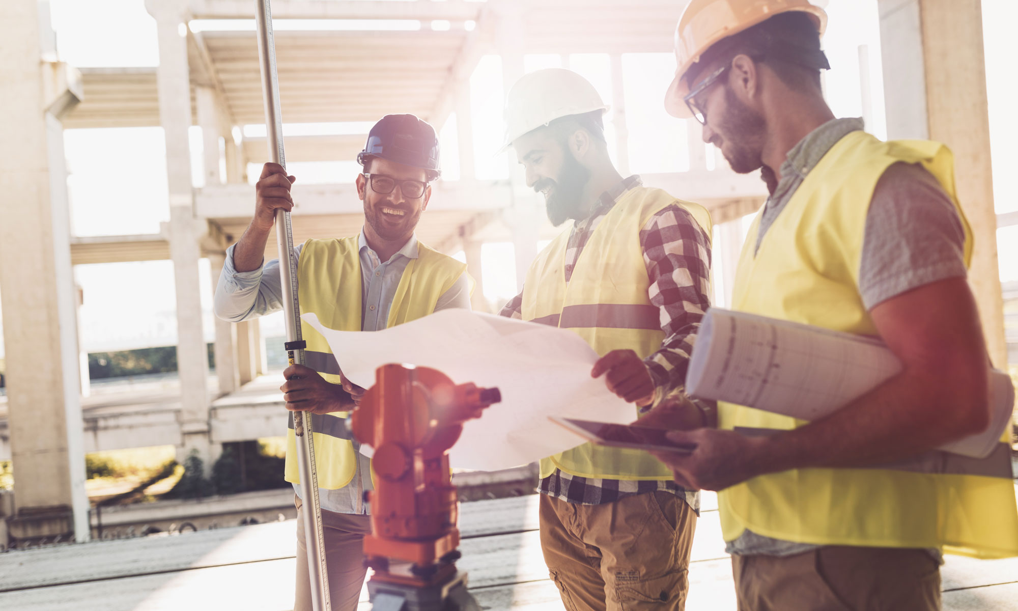 Group of construction workers discussing plans on a sunny day.