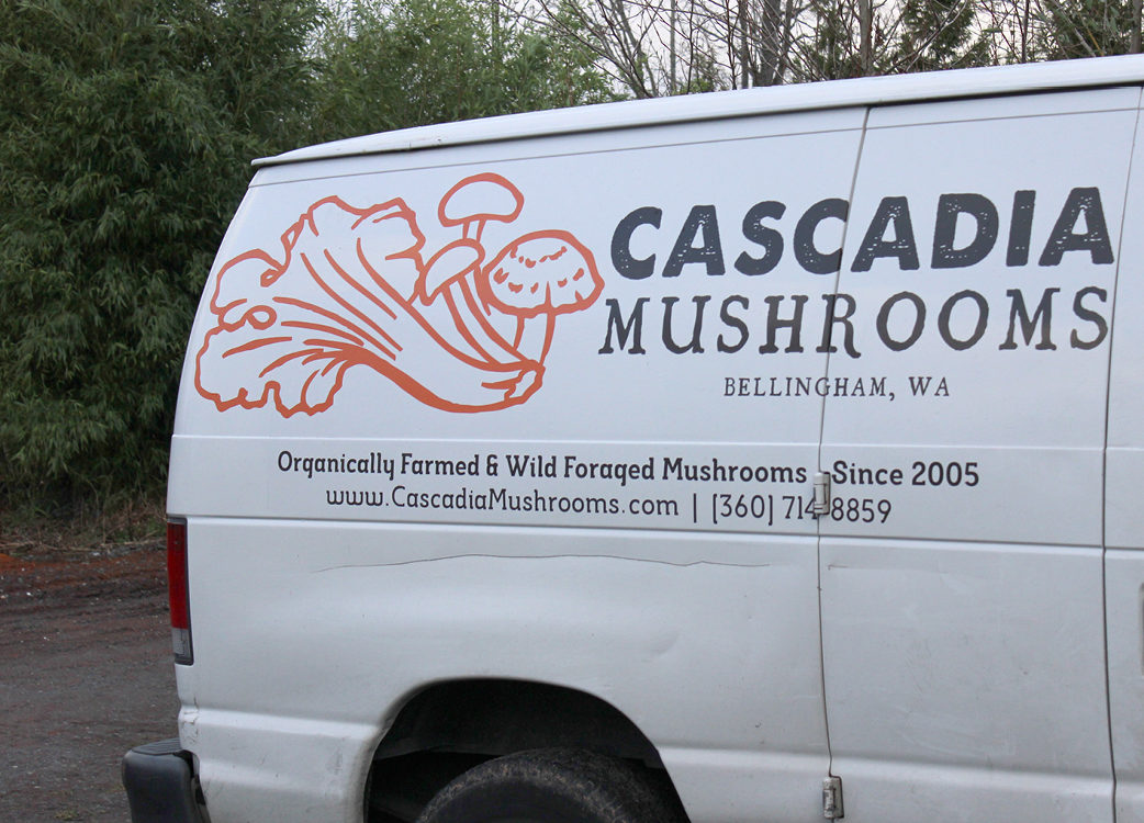 Mushroom shop van parked outside.