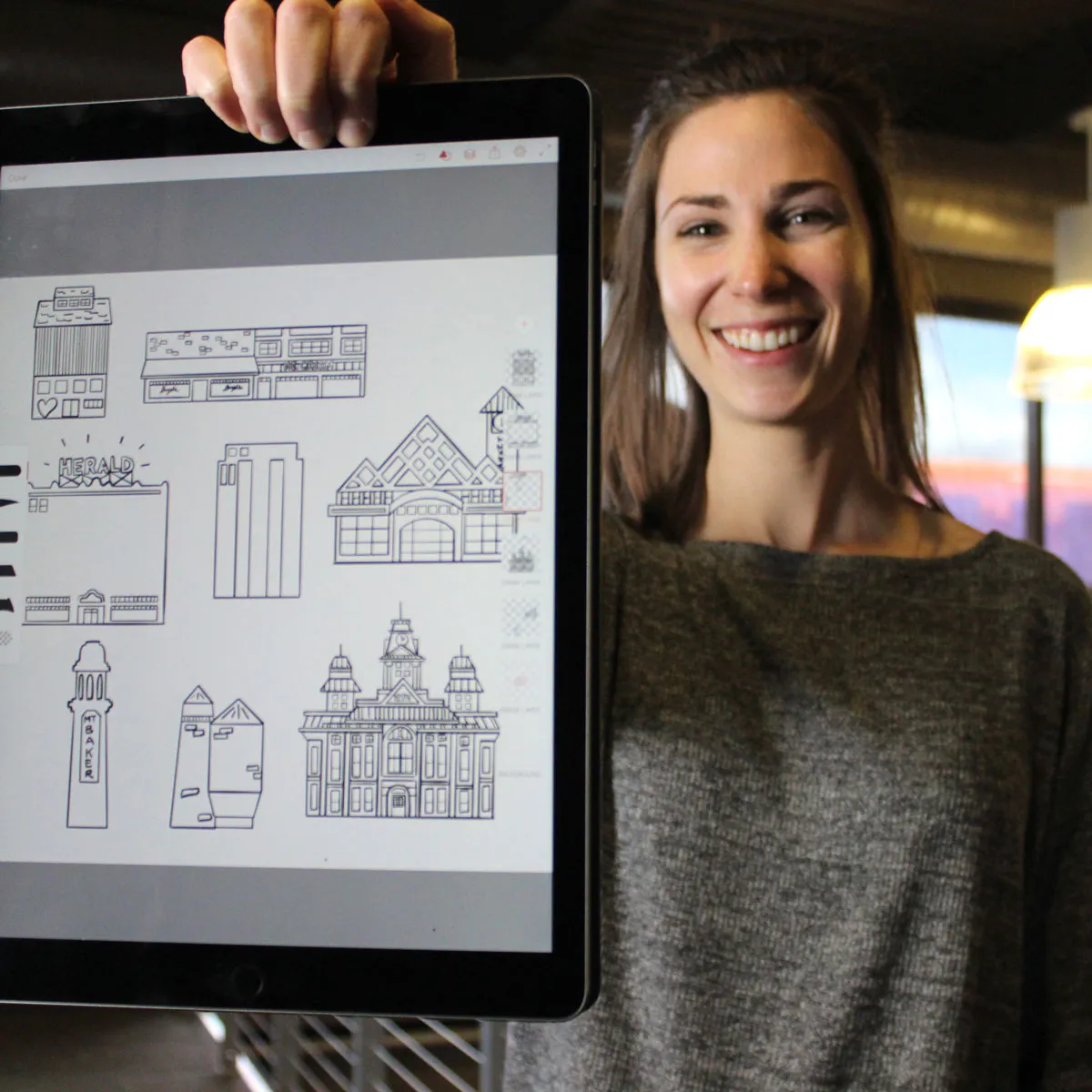 Brinn - a local graphic designer, holding some of her graphics up
