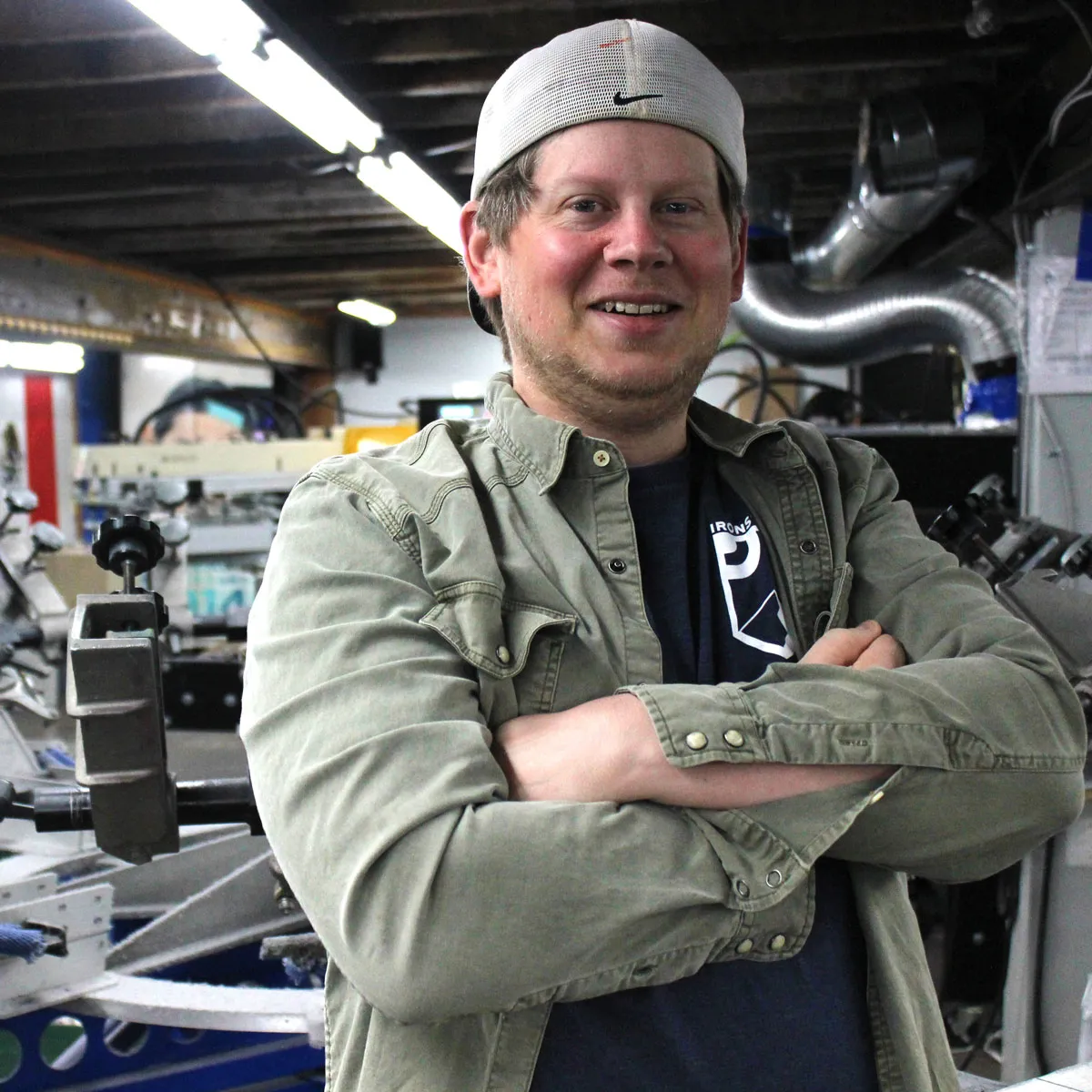 An employee from Iron Street Printing posing for a photo in his shop
