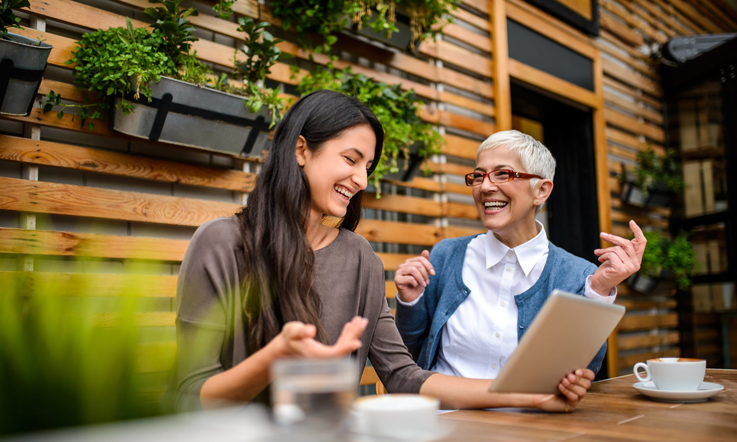 Women smiling and looking at a tablet