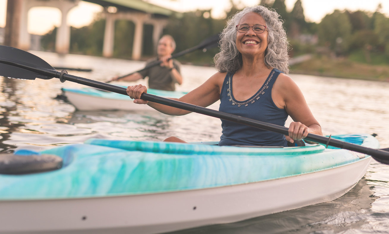 Woman paddling a kayak on a river.