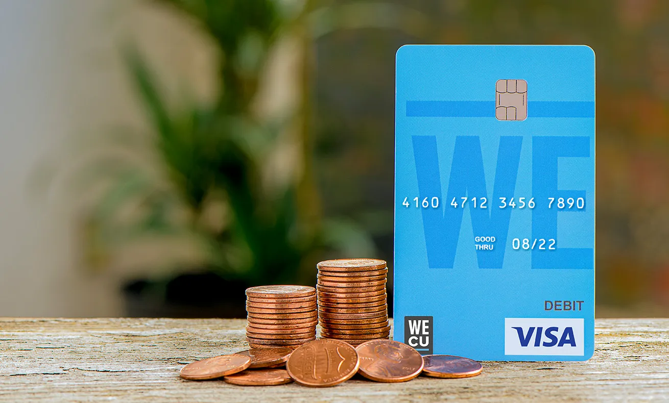 Coin collection and credit card on table.
