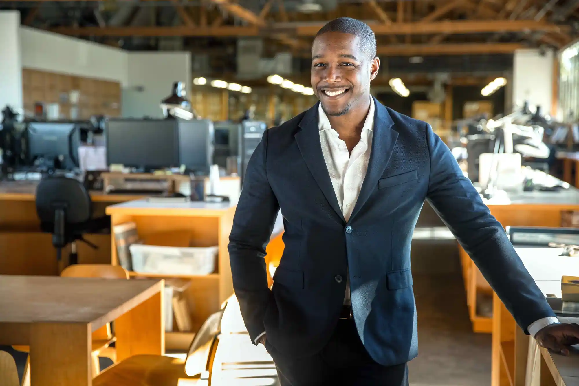A man in a suit standing in an office environment.