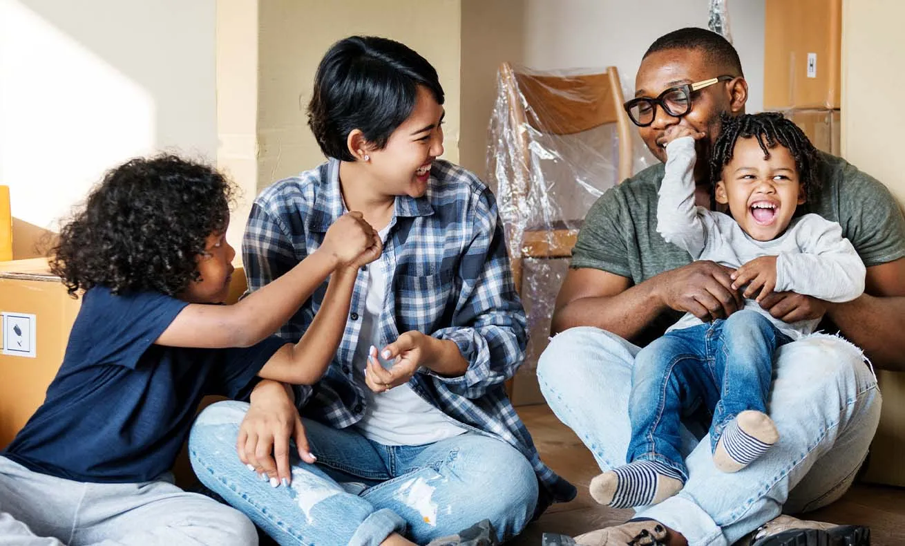 A family enjoying a moment together, with two adults and a child sharing a happy expression.