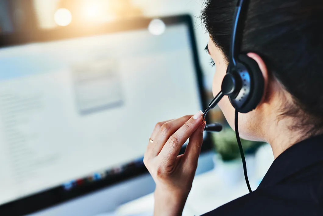 Woman working on computer while wearing headphones
