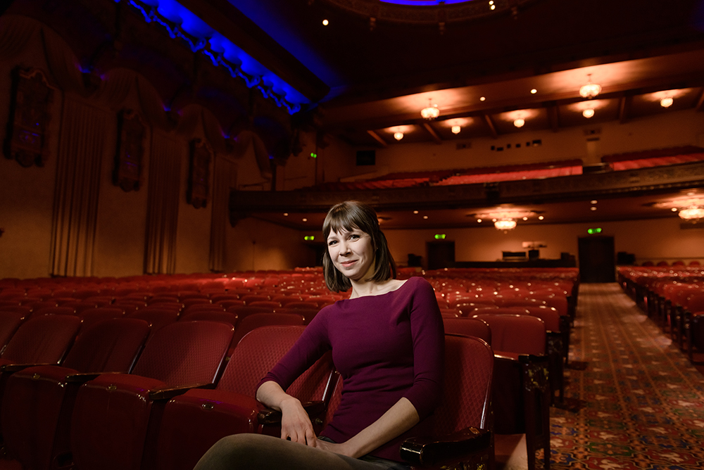 Woman sitting in an empty theater.