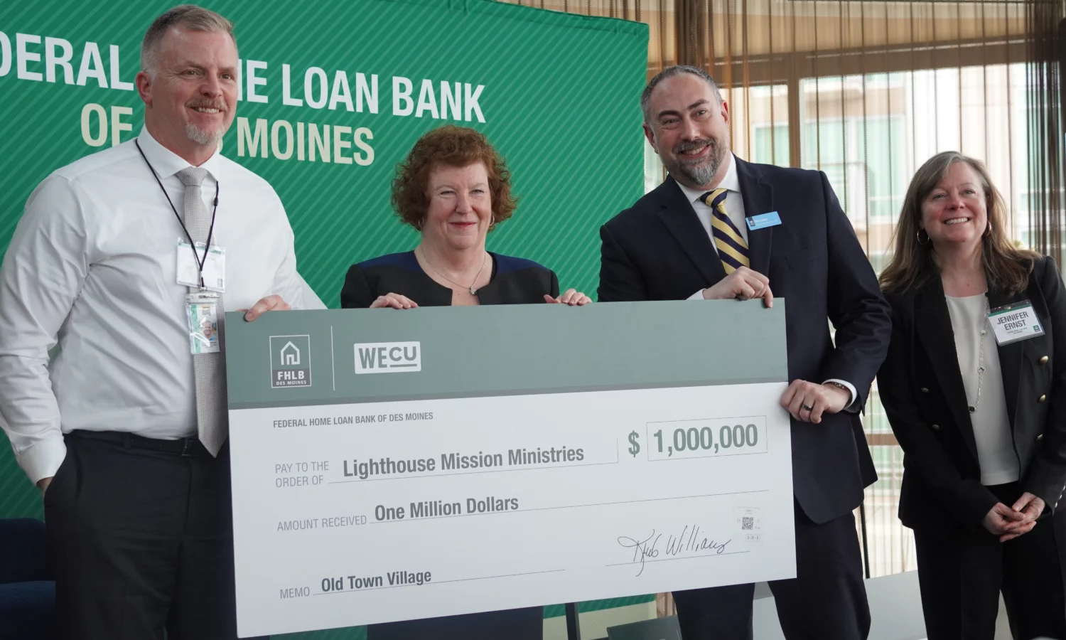 group of people behind large check