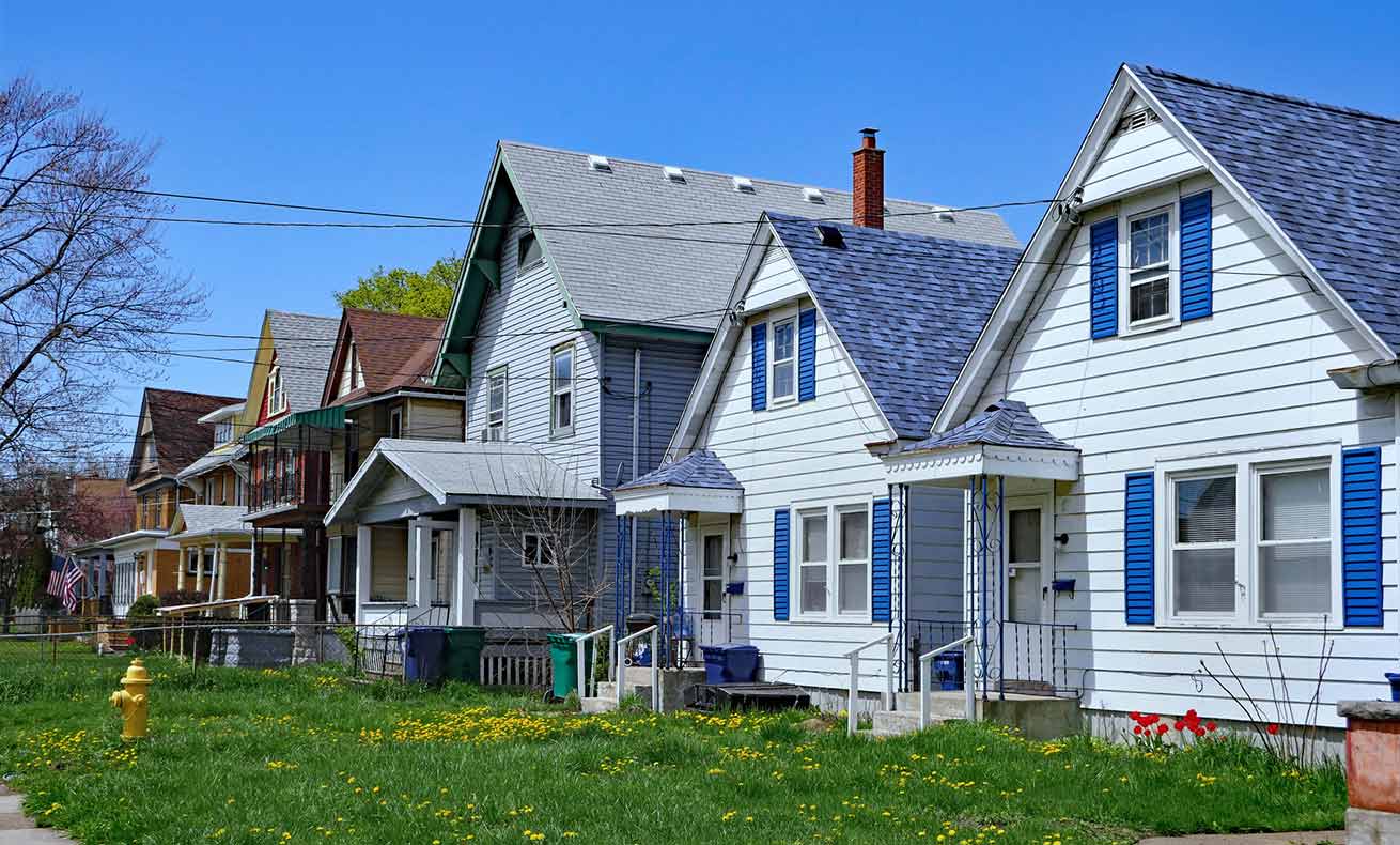 Residential neighborhood with two story homes and green lawns.