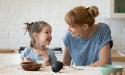 Mother and child sitting at a kitchen counter.