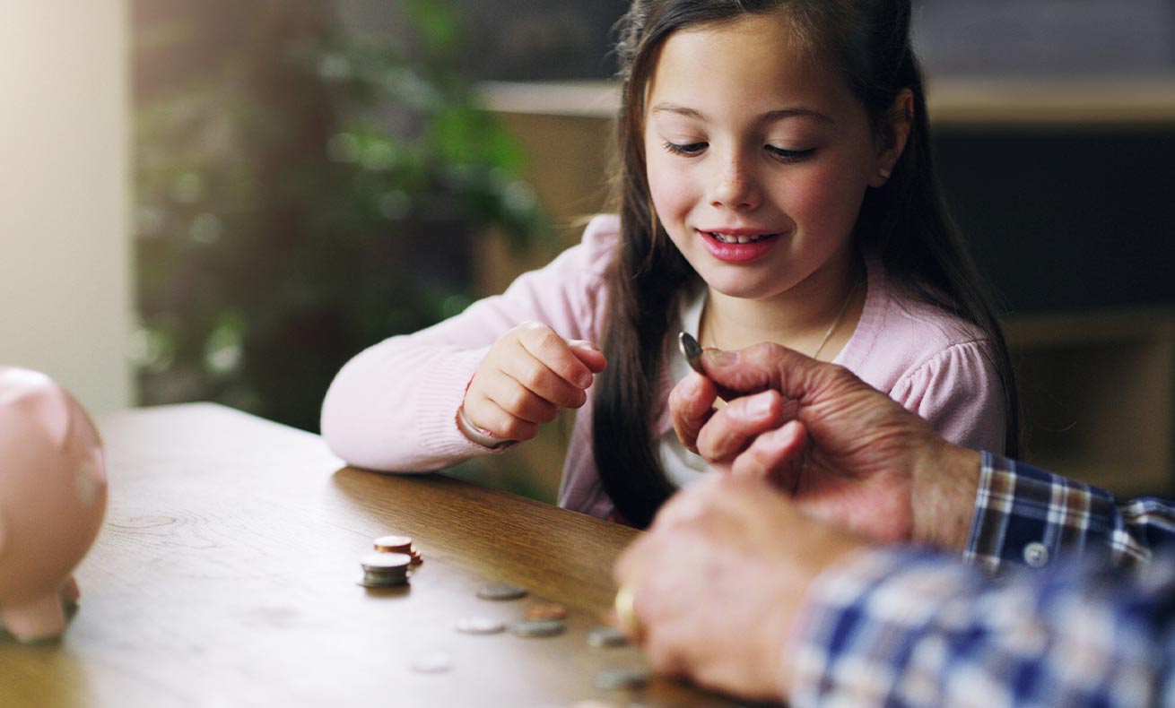 An elementary-age girl counts coins with her parents.