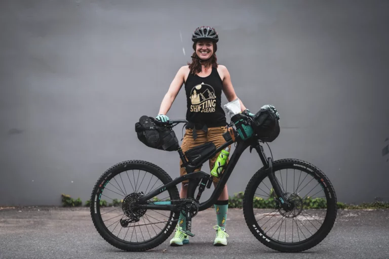 Female bicyclist with camping gear.