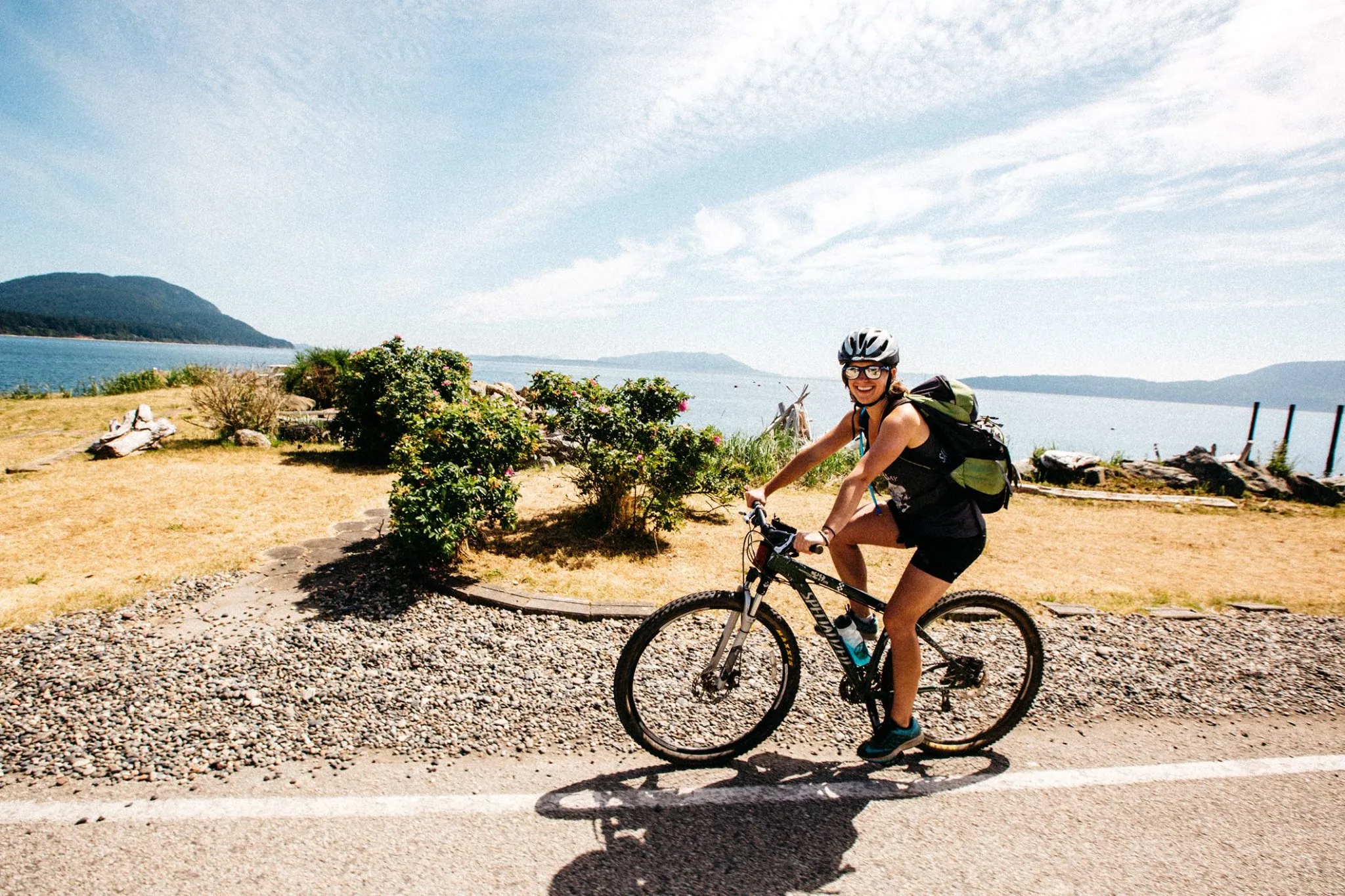 A member of Shifting Gears posing roadside next to the water.