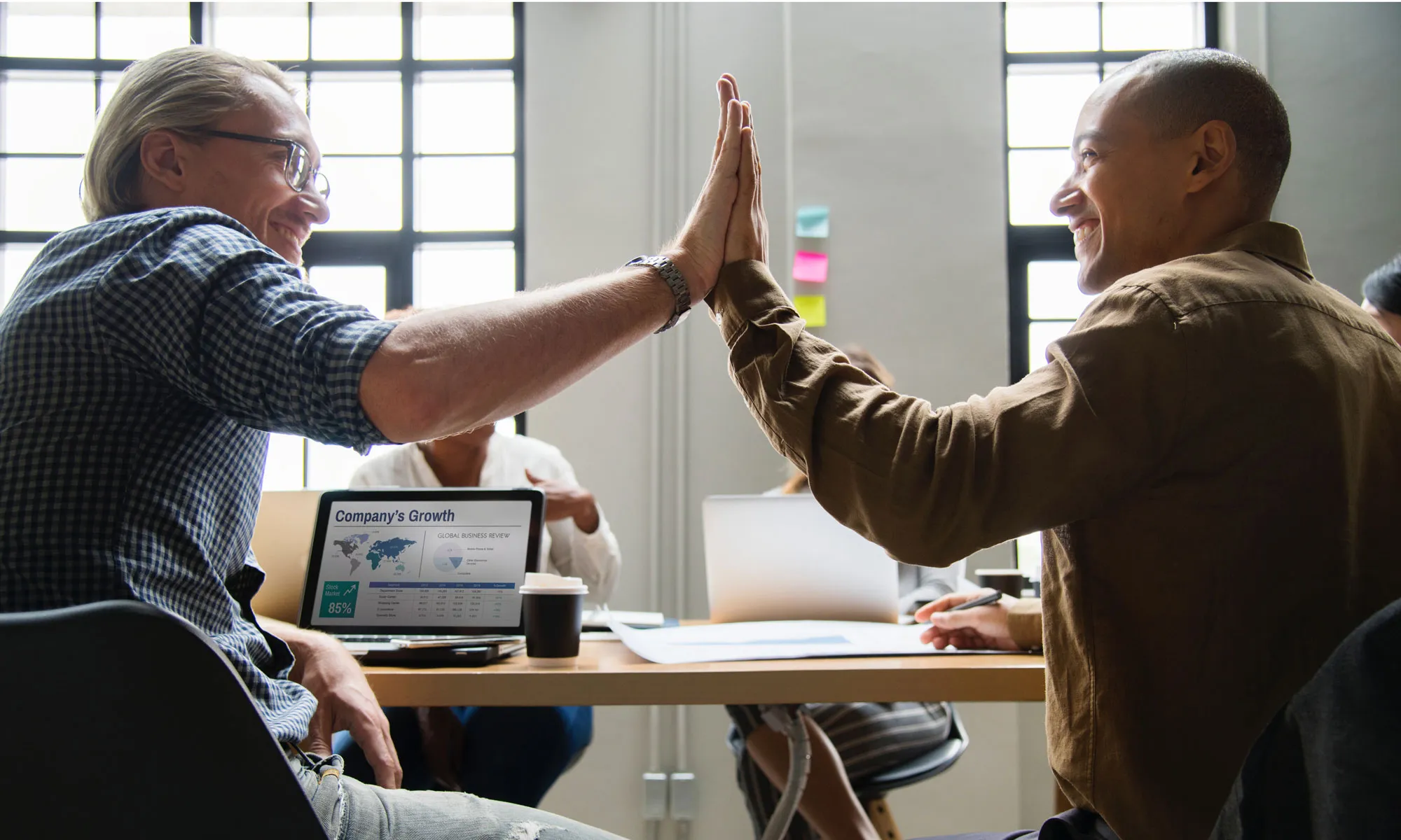 Businessman giving a high five up to another man