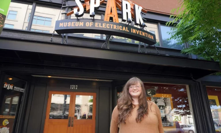 Woman standing in front of a sign.