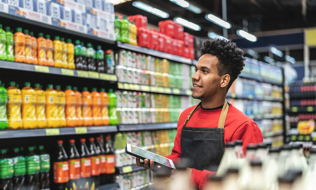 A man checks the inventory on the shelves of his store.