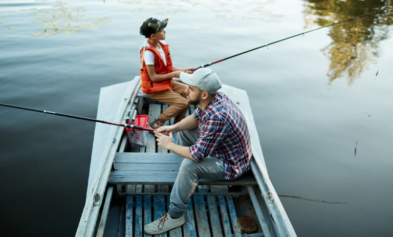 Two people fishing on a boat.