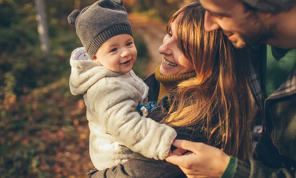 Family on a forest path, sharing a joyful moment.