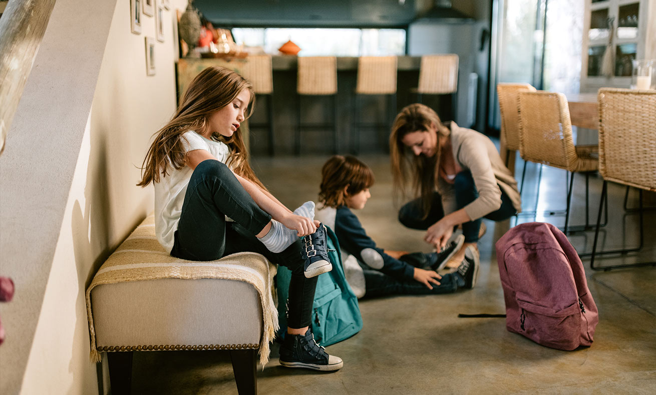 Two women and a girl preparing for school