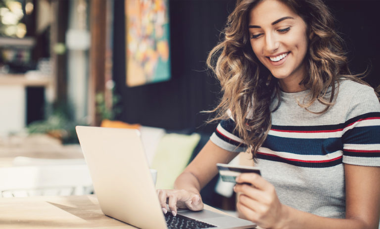 Woman smiling while working on laptop