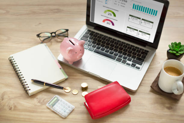 A laptop on a desk with a wallet and papers, showcasing financial management tools.