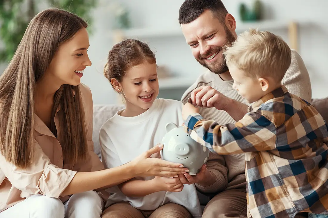 Family putting money in a piggy bank