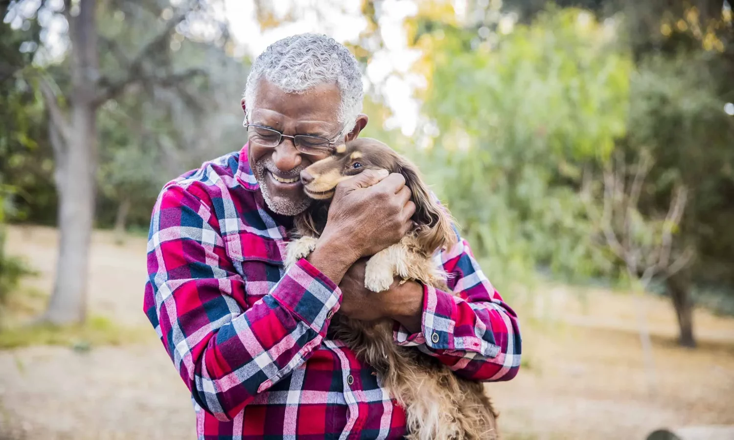 A person holding a dog in a park