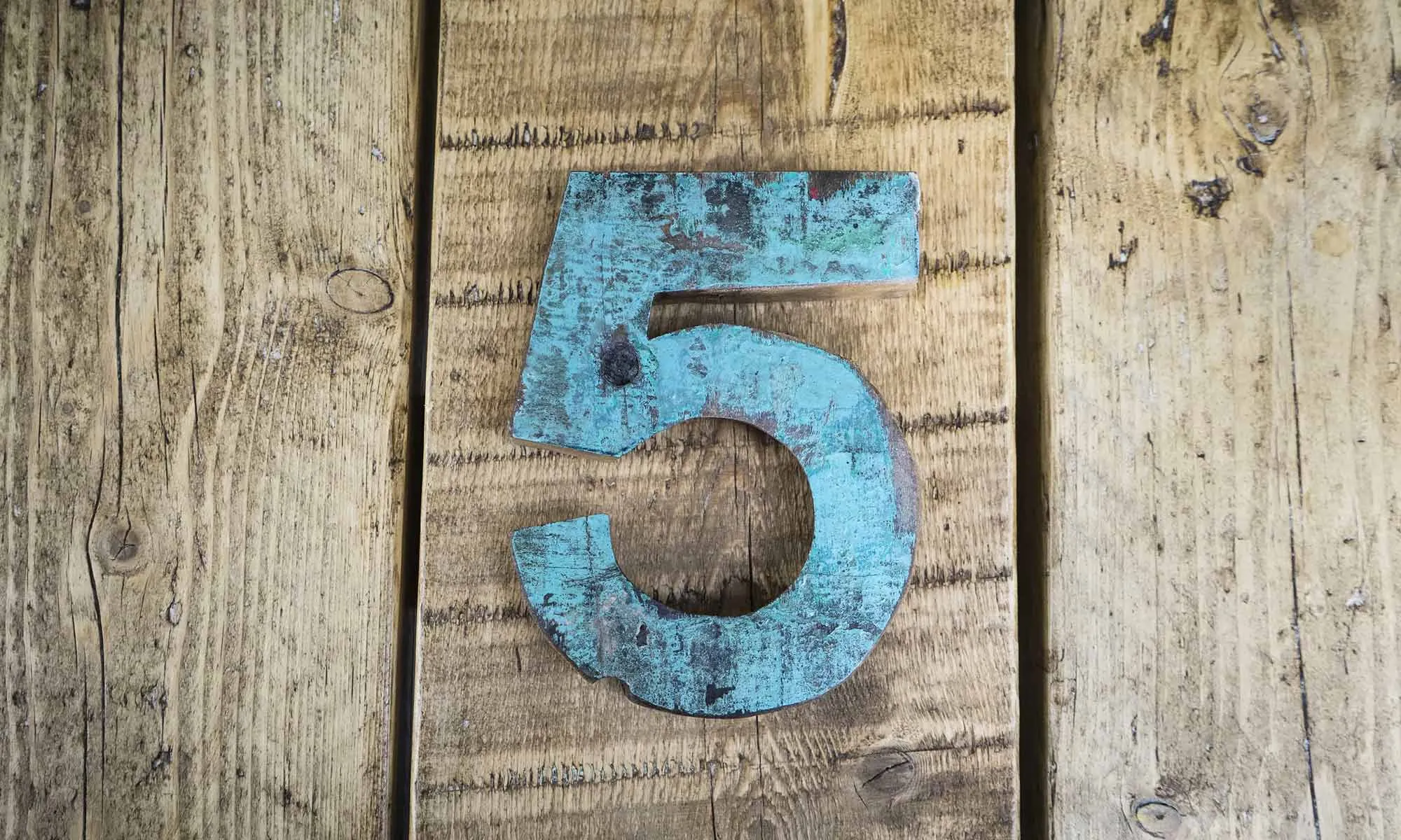 Number five sign on wooden surface