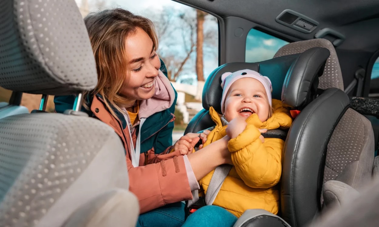mom putting baby in car seat