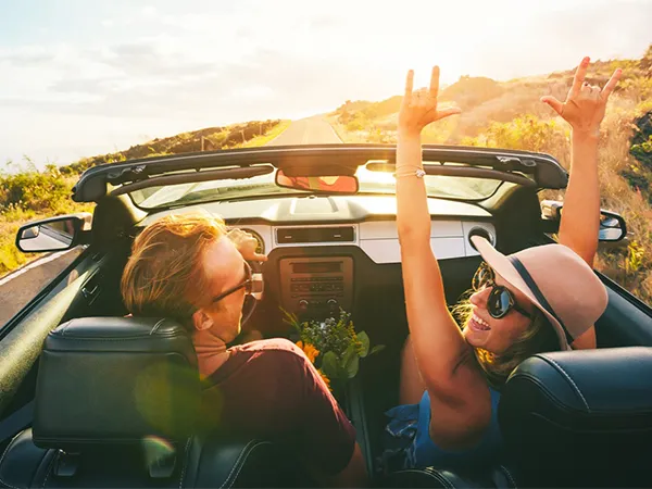 Couple celebrating in convertible car