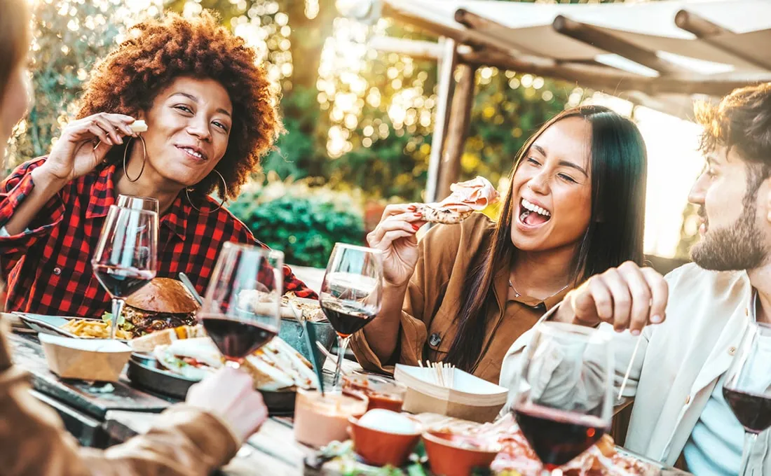 Group of people enjoying a meal together at an outdoor dining area.