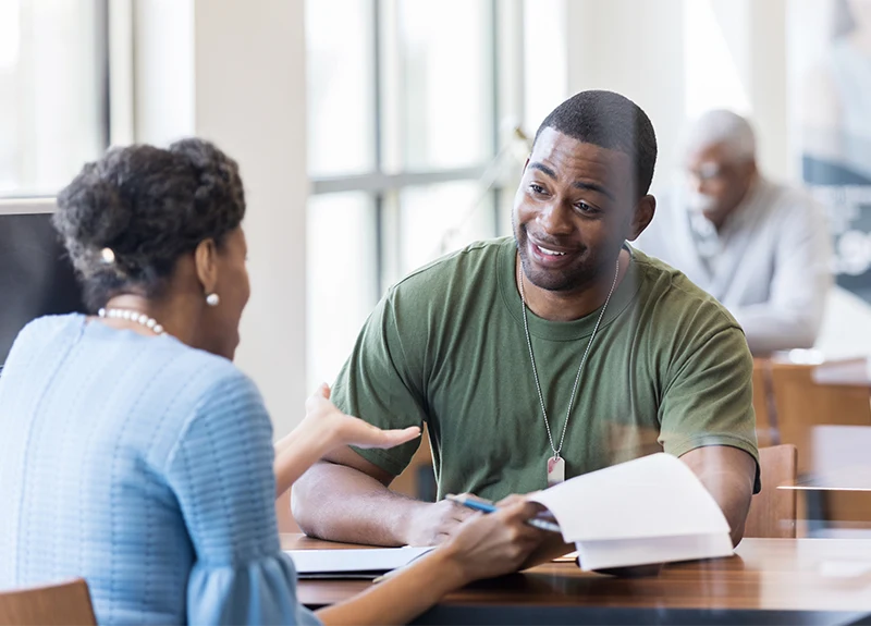 Two adults engaged in a discussion at a table.