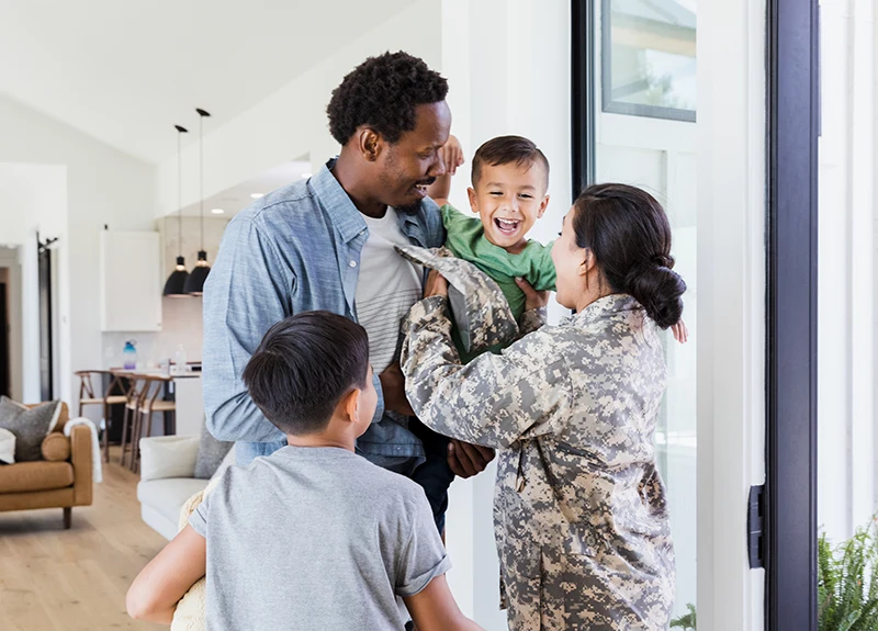 Military mom hugging family