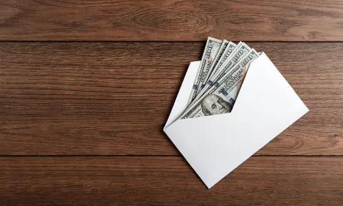 Money on the table with a white envelope.