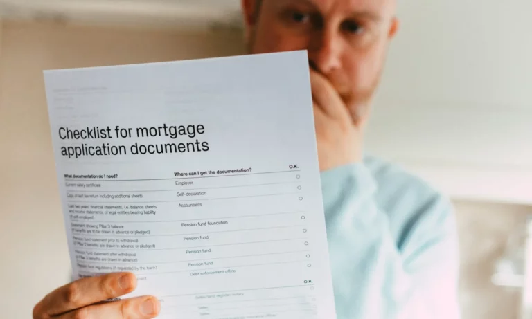 Person holding a paper with mortgage application documents on it.