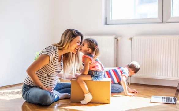 Woman in striped shirt sitting on floor, smiling at her child