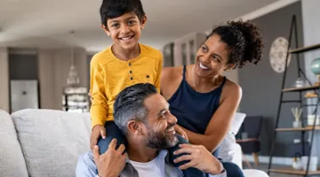 A family of three enjoying a moment together in their living room.