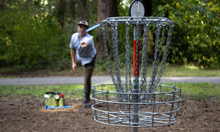 Man playing frisbee golf in park.