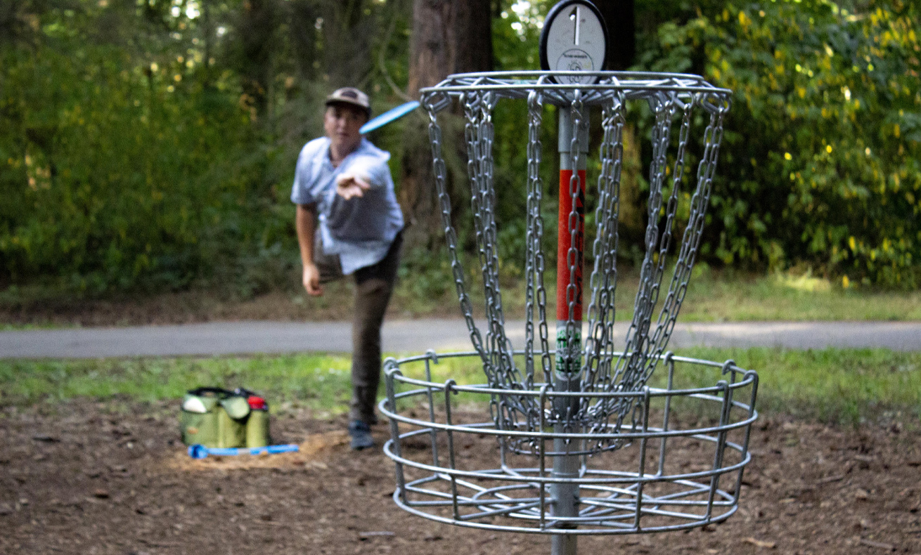 Man playing frisbee golf in park.